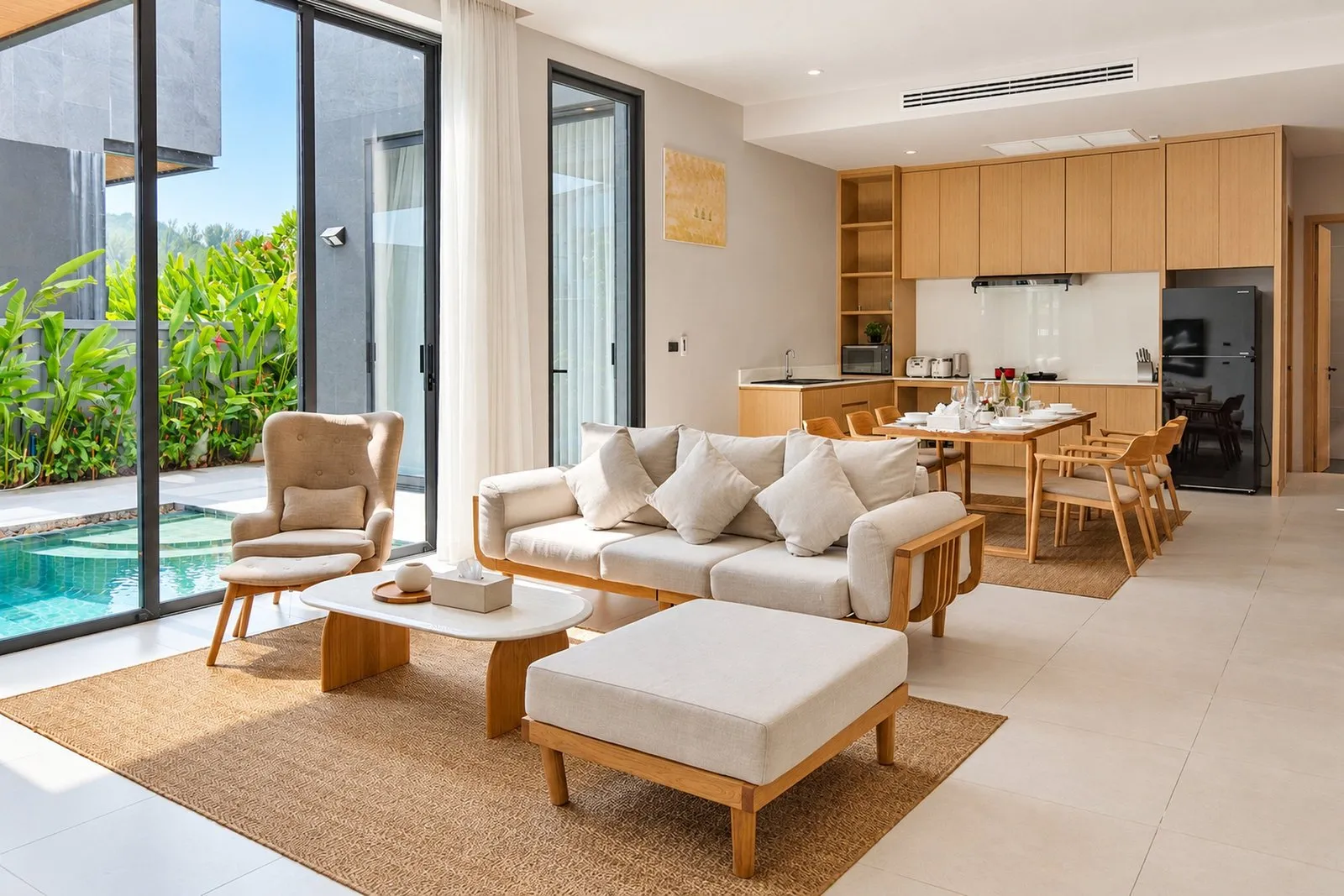 Living room open to the kitchen and the pool at Long One Villa, Phuket