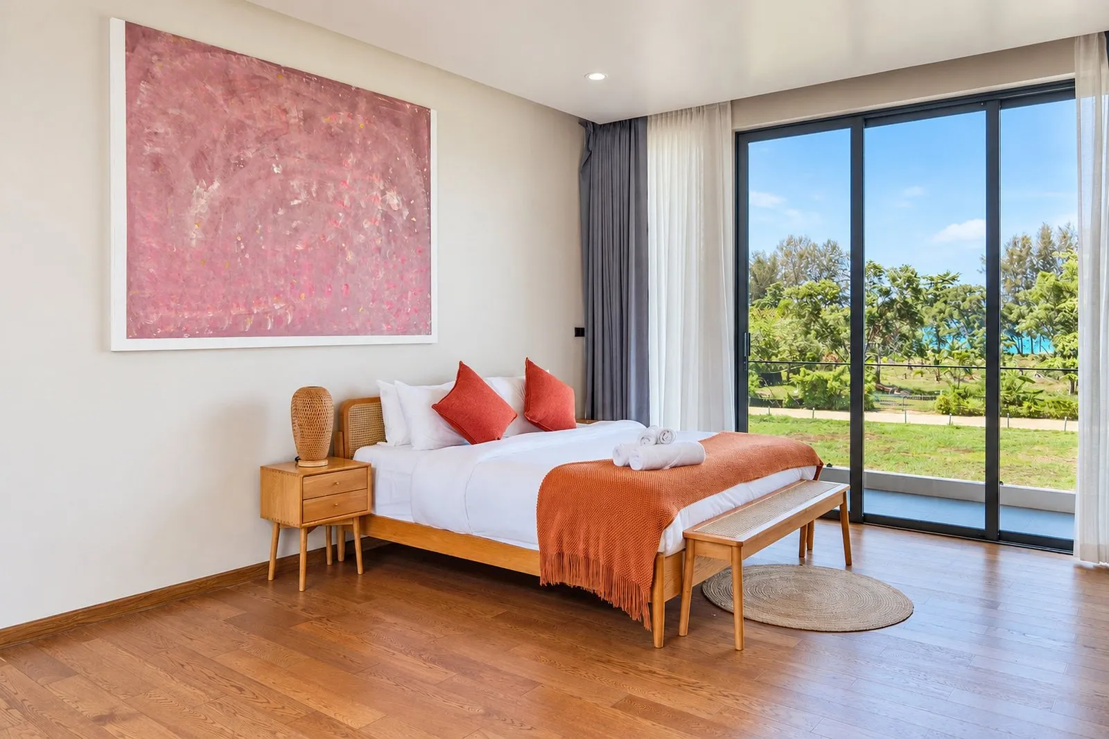 Bedroom with timber furniture and a garden view at Long One Villa, Phuket