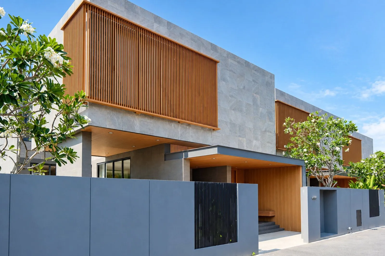 Villa exterior with timber screens and frangipani at Long One Villa, Phuket