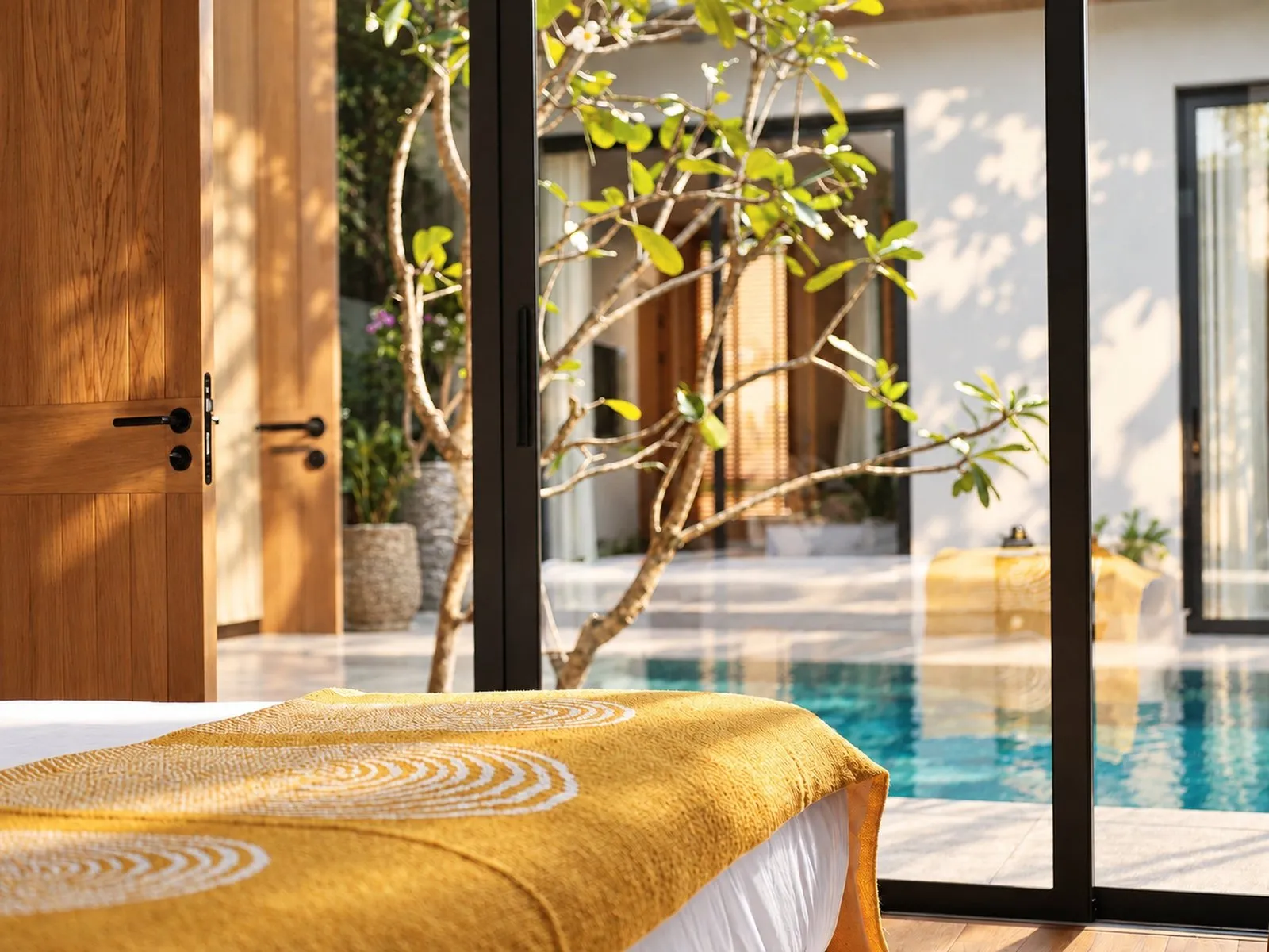 View from the bed to the courtyard through glass doors at Villa Oliver, Phuket