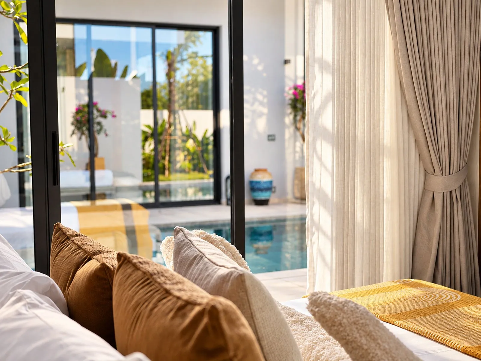 Pillows in the foreground with a view to the courtyard pool at Villa Oliver, Phuket